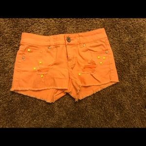 Orange studded shorts.